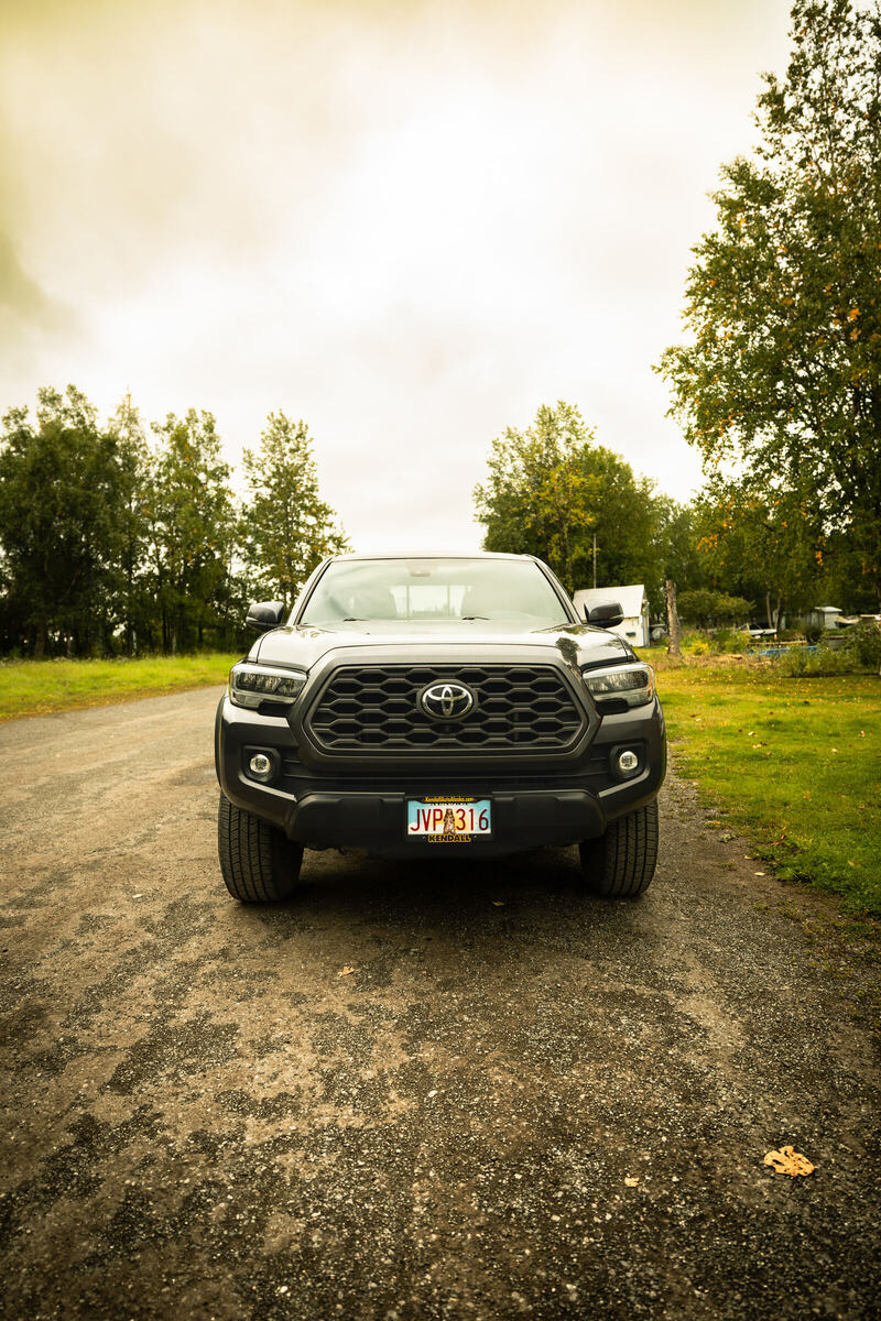 Grey Toyota Tacoma seen from the front on a gravel road