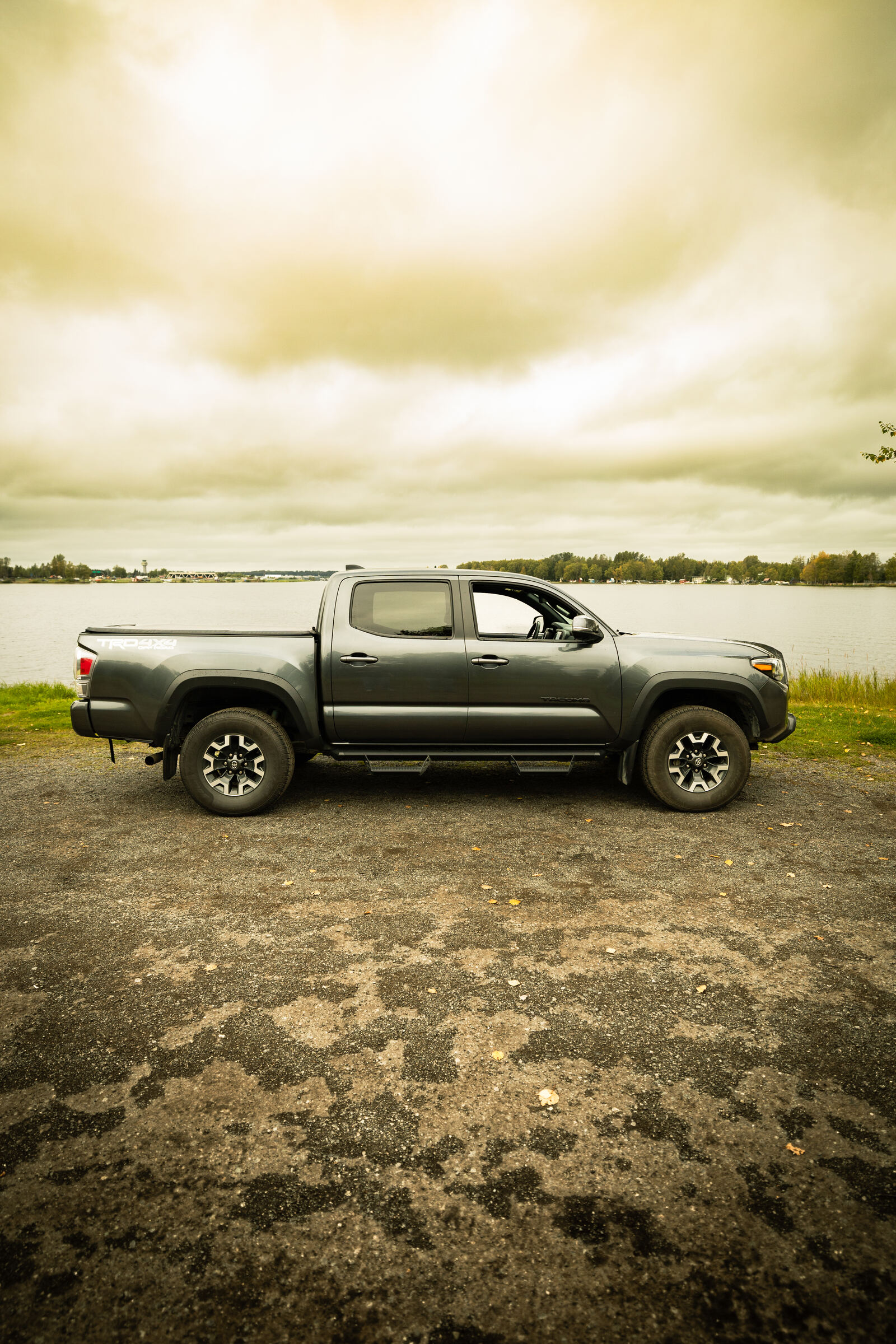 Grey Toyota Tacoma parked on the gravel shore of Lake Lucille