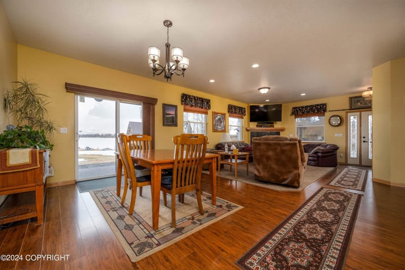 Dining table with the living room and lake windows beyond