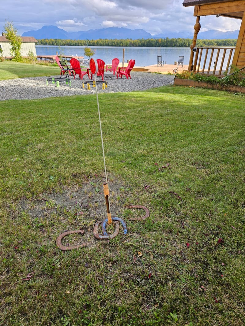Horseshoe pit on the lawn with the fire pit and lake beyond