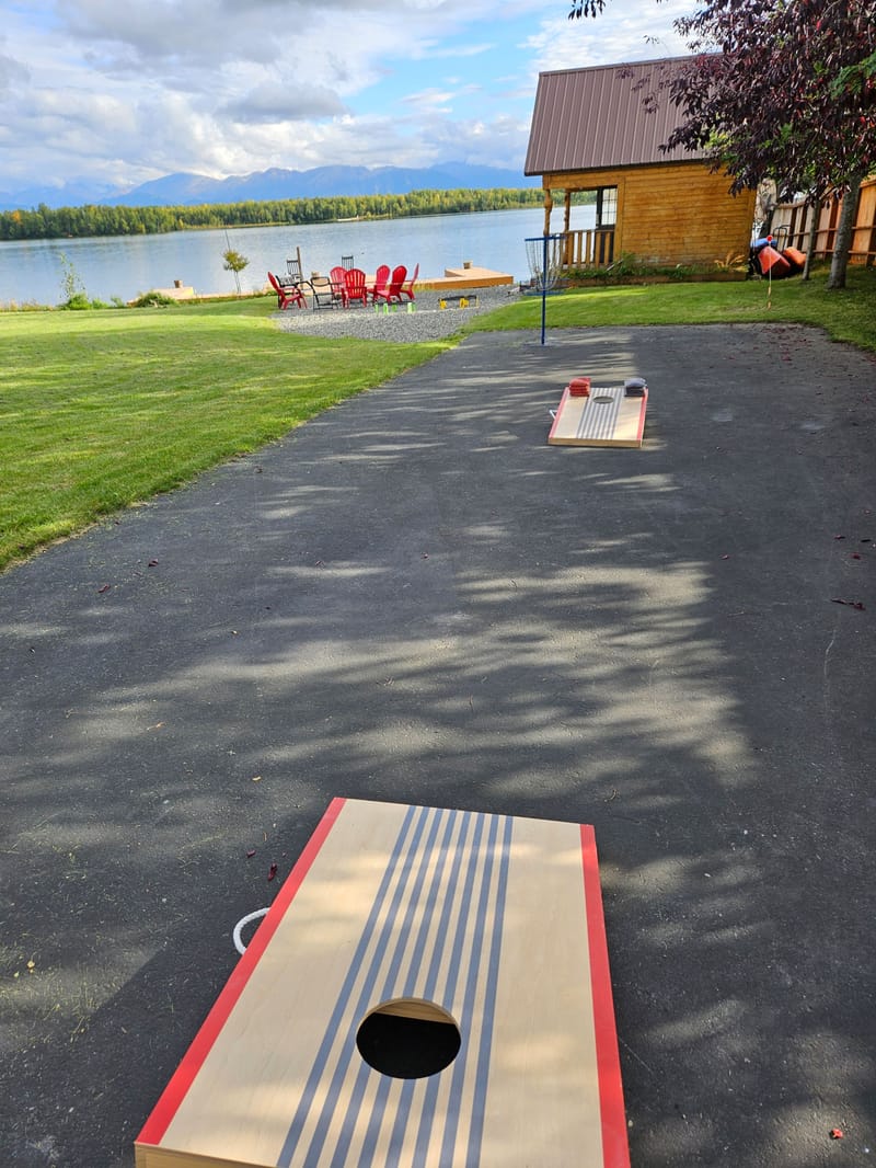 Cornhole boards on the path down to the lake