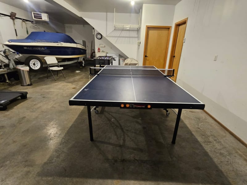 Ping pong table in the garage with the boat parked behind