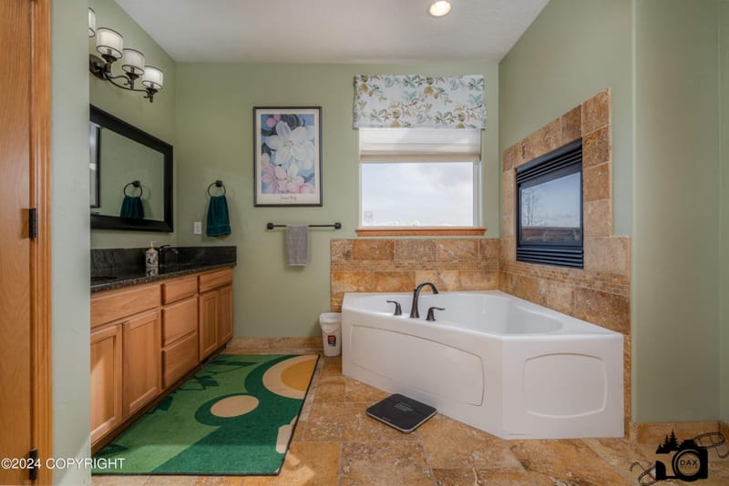 Primary bathroom with a soaking tub under the window and a double vanity