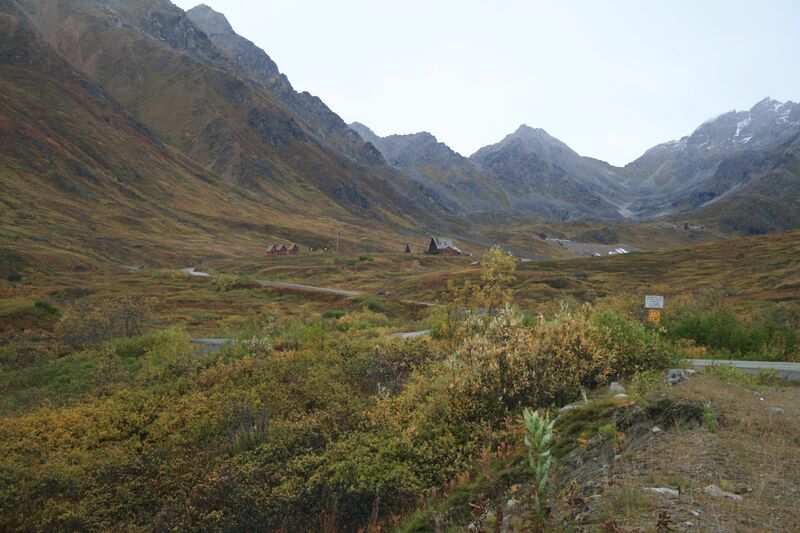Autumn tundra and a road winding up a mountain valley at Hatcher Pass